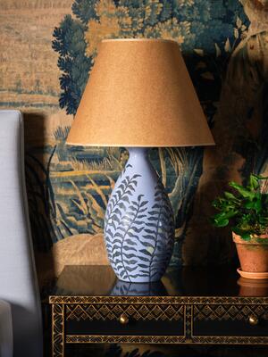 A delicate fern motif graces this lamp, its fronds gracefully unfurling along the vase