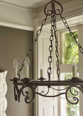 A circular frame and whimsical curves provide a graceful contrast to the rust-effect finish of the Rye chandelier