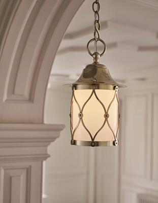 A brass lattice frames the opaline glass cylinder shade of the Finkley lantern