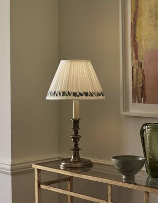 In cast brass with a light bronze finish, the Childrey candlestick table lamp recalls designs of the 16th century