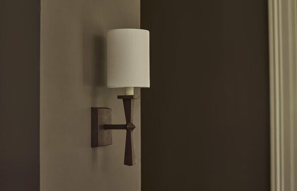 The midcentury design and rust-effect finish of the Lancing wall light echo elements of the Corfe chandelier