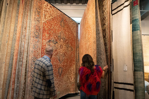 Guests browsing Surya's one-of-a-kind antique rugs