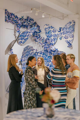 Guests in front of a butterfly installation featuring the collection’s Rorschach print