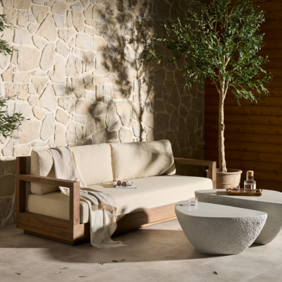 Venda is a simple outdoor sofa upholstered in durable neutral fabric framed by FSC-certified teak in a toasted brown finish