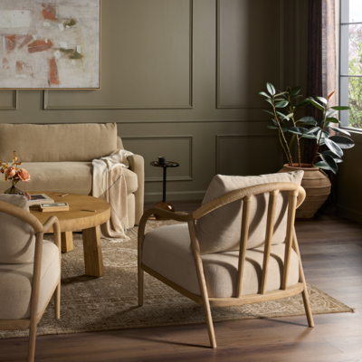 Plush feather-blend cushions are upholstered in a neutral performance fabric in the Remi chair, with rush cord detailing wrapping the top edge of an exposed oak frame and spindle back
