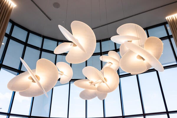 A light fixture by Italian firm Luceplan is a focal point of the showroom’s two-story lobby
