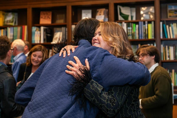 Kendall Wilkinson (right) embraces a guest