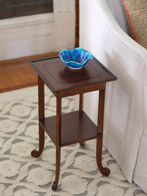 The Belle drinks table features elegantly splayed legs ending in rounded scrolls