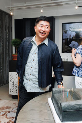 In celebration of his firm’s 25th anniversary, Jiun Ho poses with a cake in  the shape of his iconic Colina sofa
