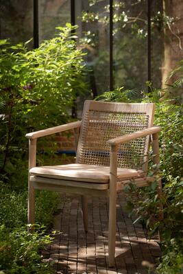 The David dining armchair has a woven back and sleek teak frame that pair perfectly with the David dining table