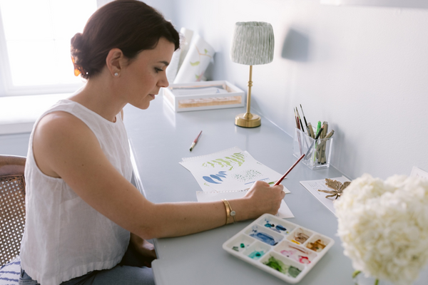 Artist and founder Kristen Leigh Steen at her desk, painting her next collection