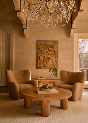 Eik round coffee table flanked by Papa Teddy chairs in Camel boucle 