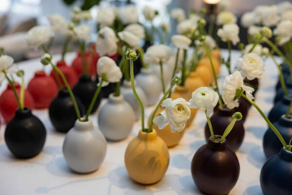 Ranunculus in colorful bud vases in assorted matte glazes