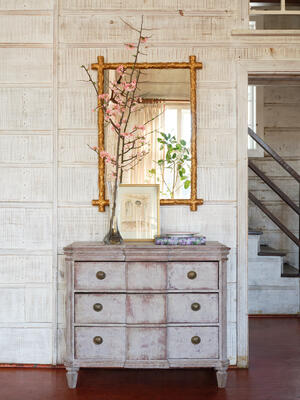 Gilded branches frame the Tivoli mirror in a way that feels equal parts garden folly and grand salon