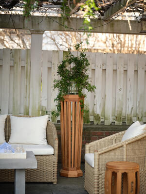 The Kent outdoor pedestal, crafted from teak, is perfect for elevating a prized plant