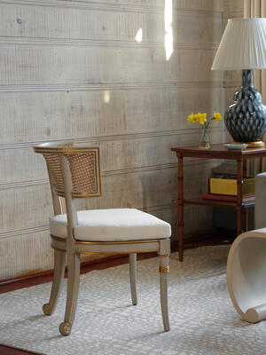 The Piedmont occasional chair features a curved, caned back and removable cushion