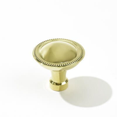 The Montclair round knob in polished brass, designed by Suzanne Kasler for Art & Forge