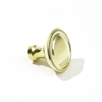 The Montclair round knob in unlacquered polished brass, designed by Suzanne Kasler for Art & Forge
