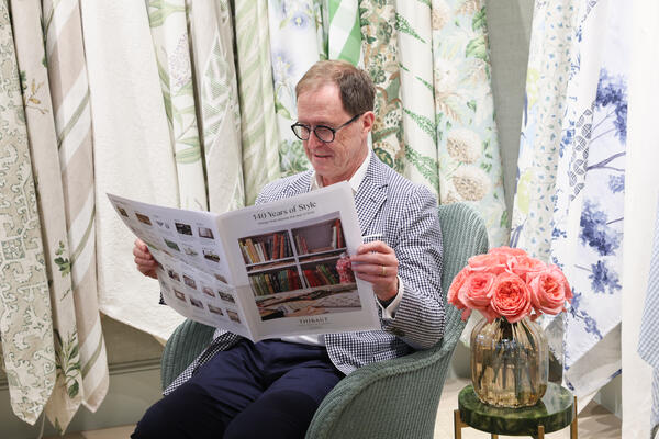 Bill Sorrell, creative director of Thibaut, reading a newspaper-inspired piece about the company’s 140-year
anniversary