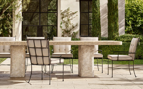 Lourdes dining table in cast stone, shown with Verano dining chairs