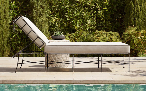 Verano adjustable chaise in all-weather stainless steel, shown with the Palma side table