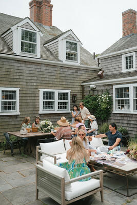 Guests picnicking beside a table displaying The Vale London’s outdoor fabrics