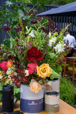 Seasonal floral arrangements displayed in custom Benjamin Moore x Jiun Ho paint cans brought the event’s color story to life