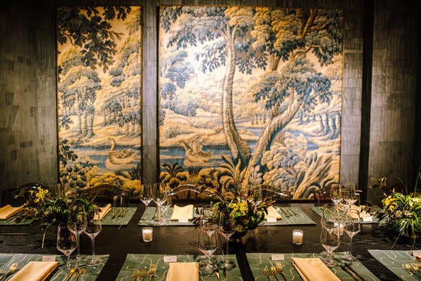 Guests dined at a table beneath a design from Arte’s Les Tapisseries collection